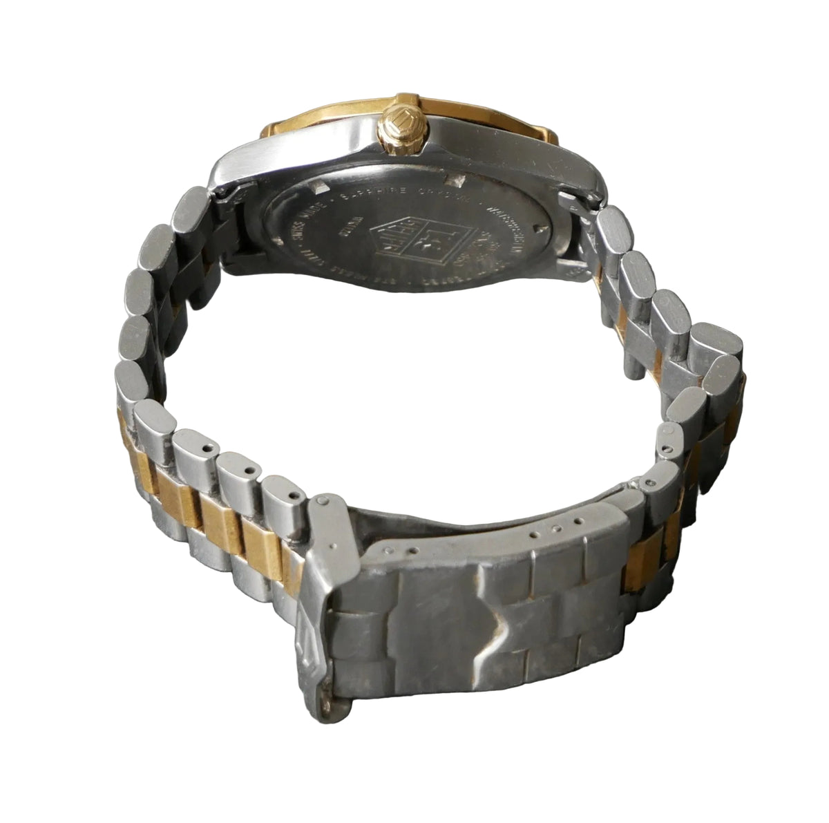 Metallic watch band on a gray surface