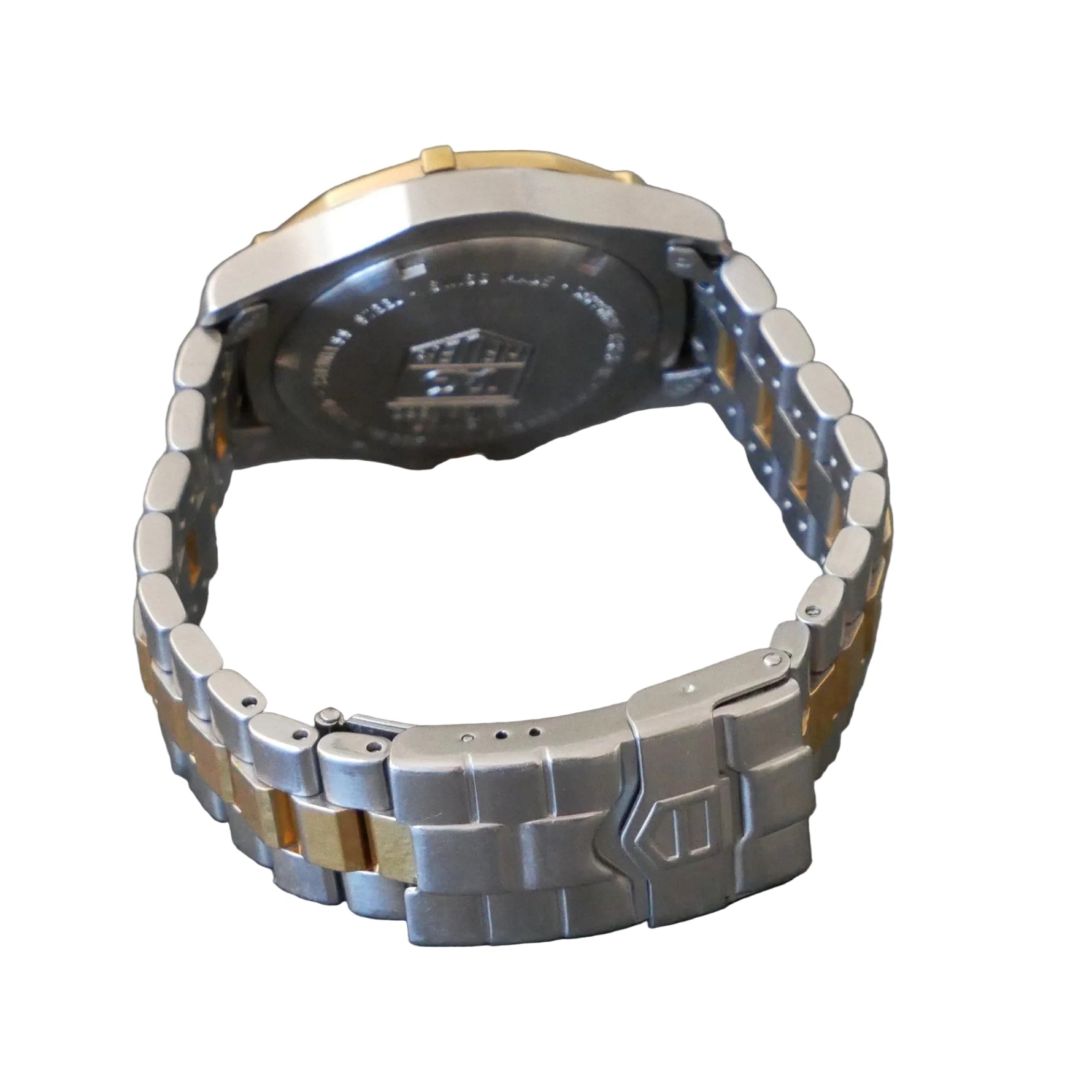 Silver and gold watch on a gray surface