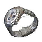 Silver wristwatch on a clear stand against a dark background