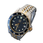 TAG Heuer Submariner Date watch with a two-tone stainless steel and gold bracelet, featuring a dark blue dial and bezel.