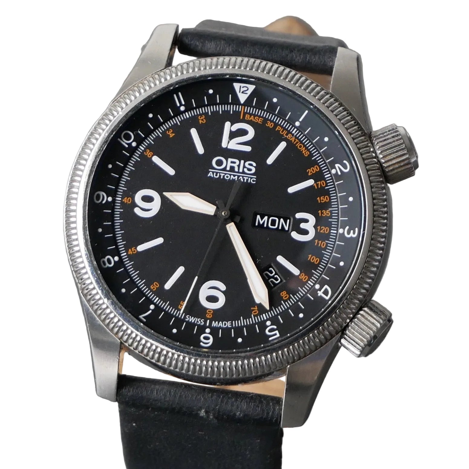 An Oris Automatic watch with a black dial, silver stainless steel case, and a black leather strap, shown close-up against a gray textured background.