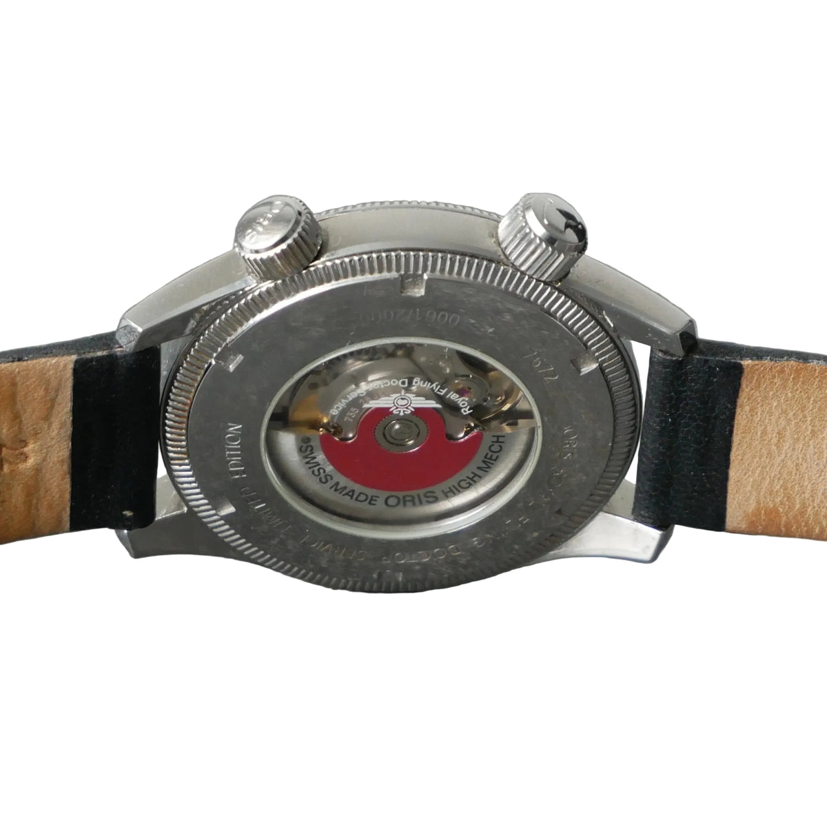 Close-up of the back of a wristwatch with a silver metal case, visible mechanical movement through the center, and a tan leather strap with black edges, set against a gray textured background.