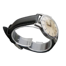 Load image into Gallery viewer, Vintage watch with black strap and beige dial on a gray background
