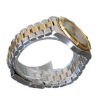 Silver and gold watch on a clear stand against a gray background