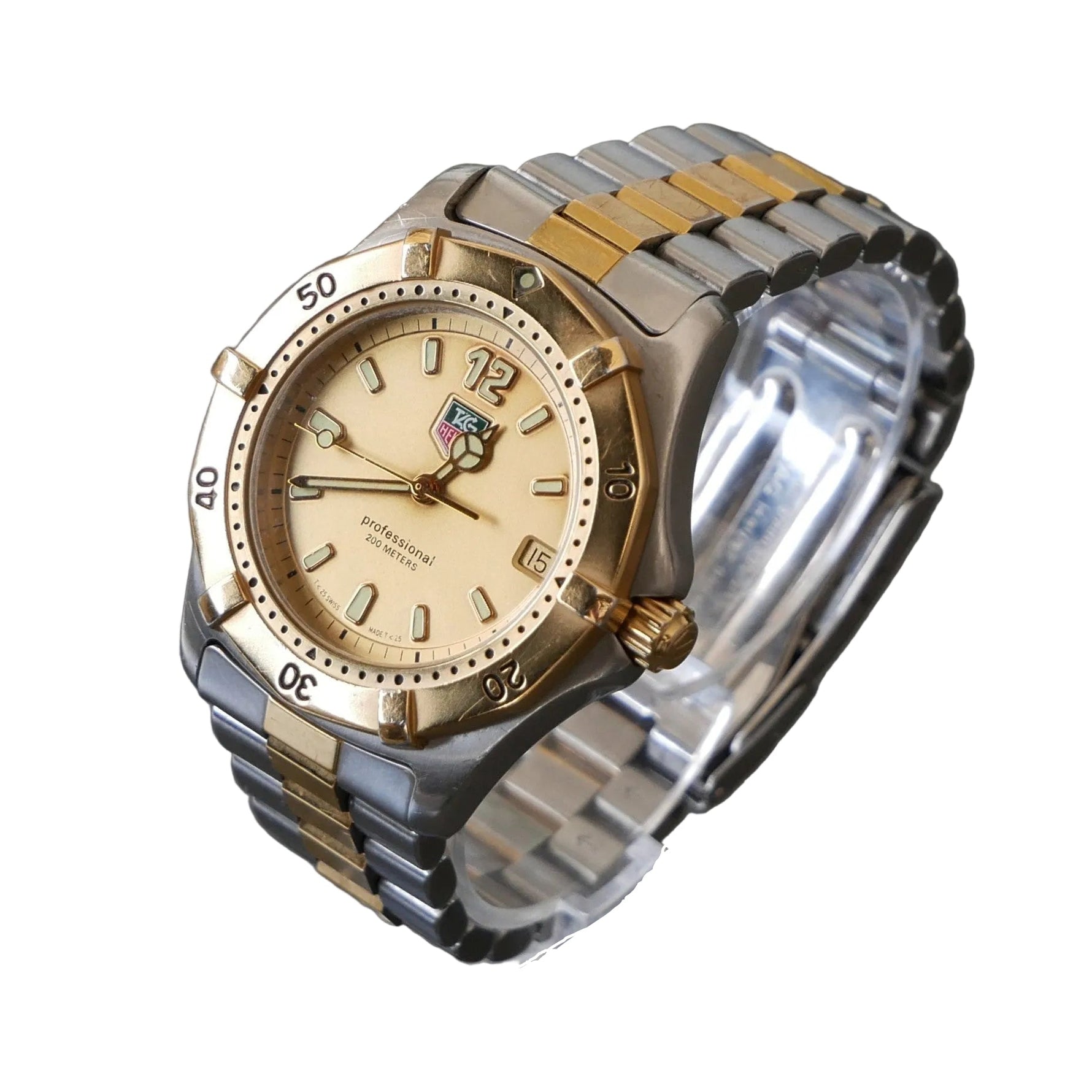 Two-tone watch with gold and silver band on a clear stand against a dark background
