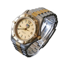Load image into Gallery viewer, Two-tone watch with gold and silver band on a clear stand against a dark background
